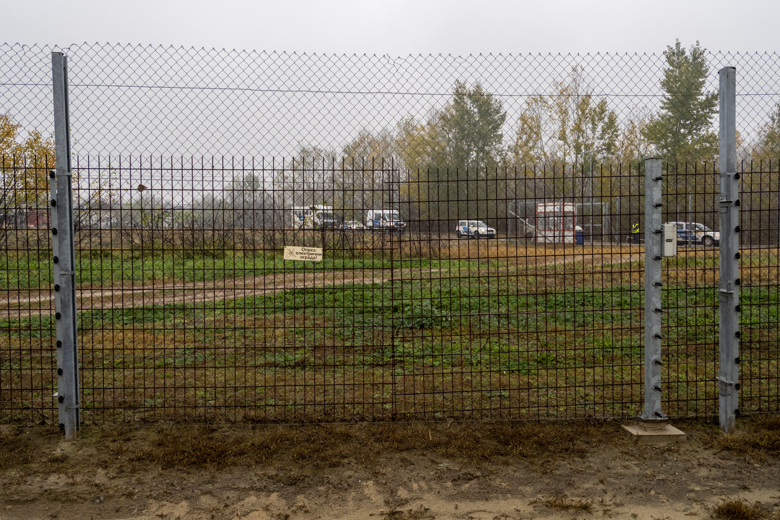 A police transport carrying people who crossed the border unauthorised approaches the fence